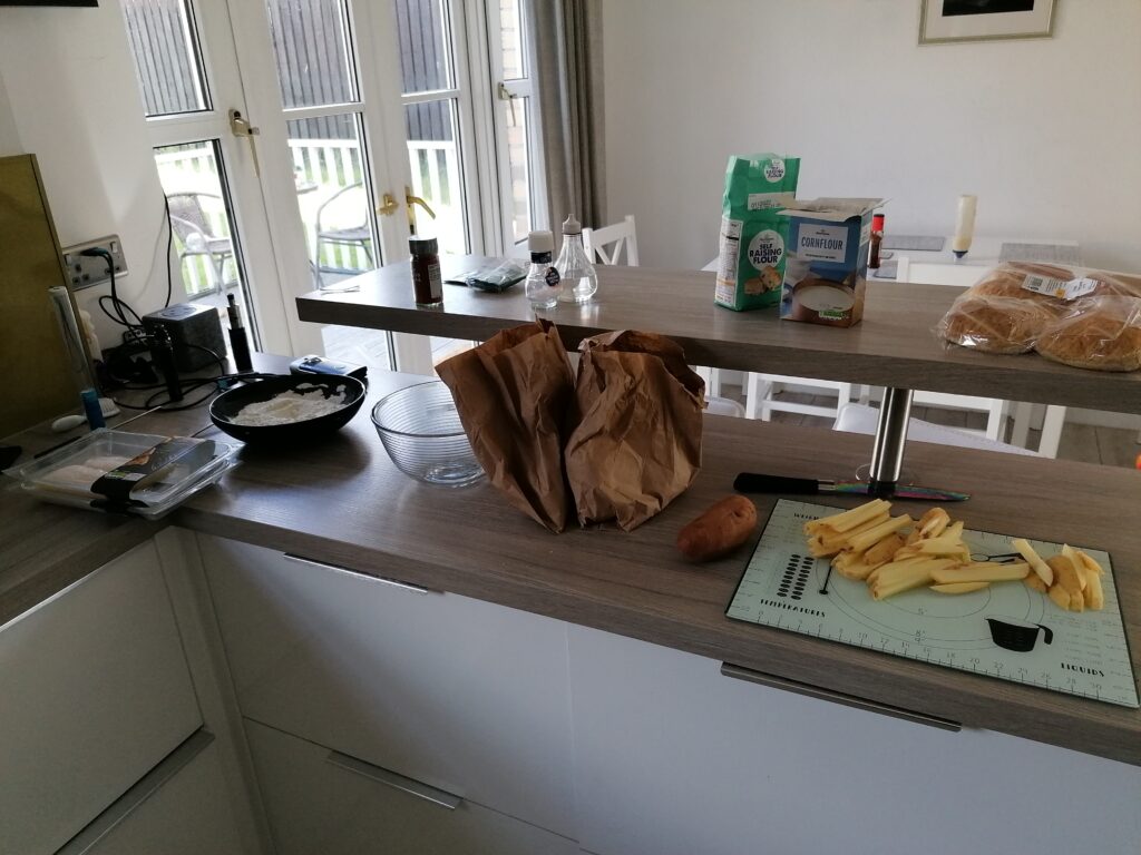 Chips cooking alongside the battered haddock