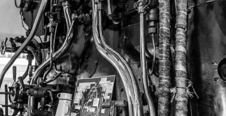 Black and white photo showing intricate steam train controls and gauges.