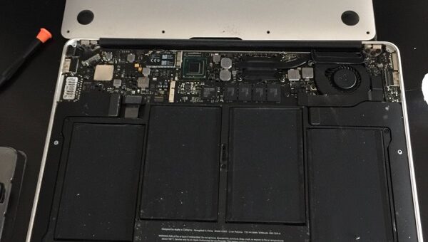MacBook Air with the bottom case removed to show the battery